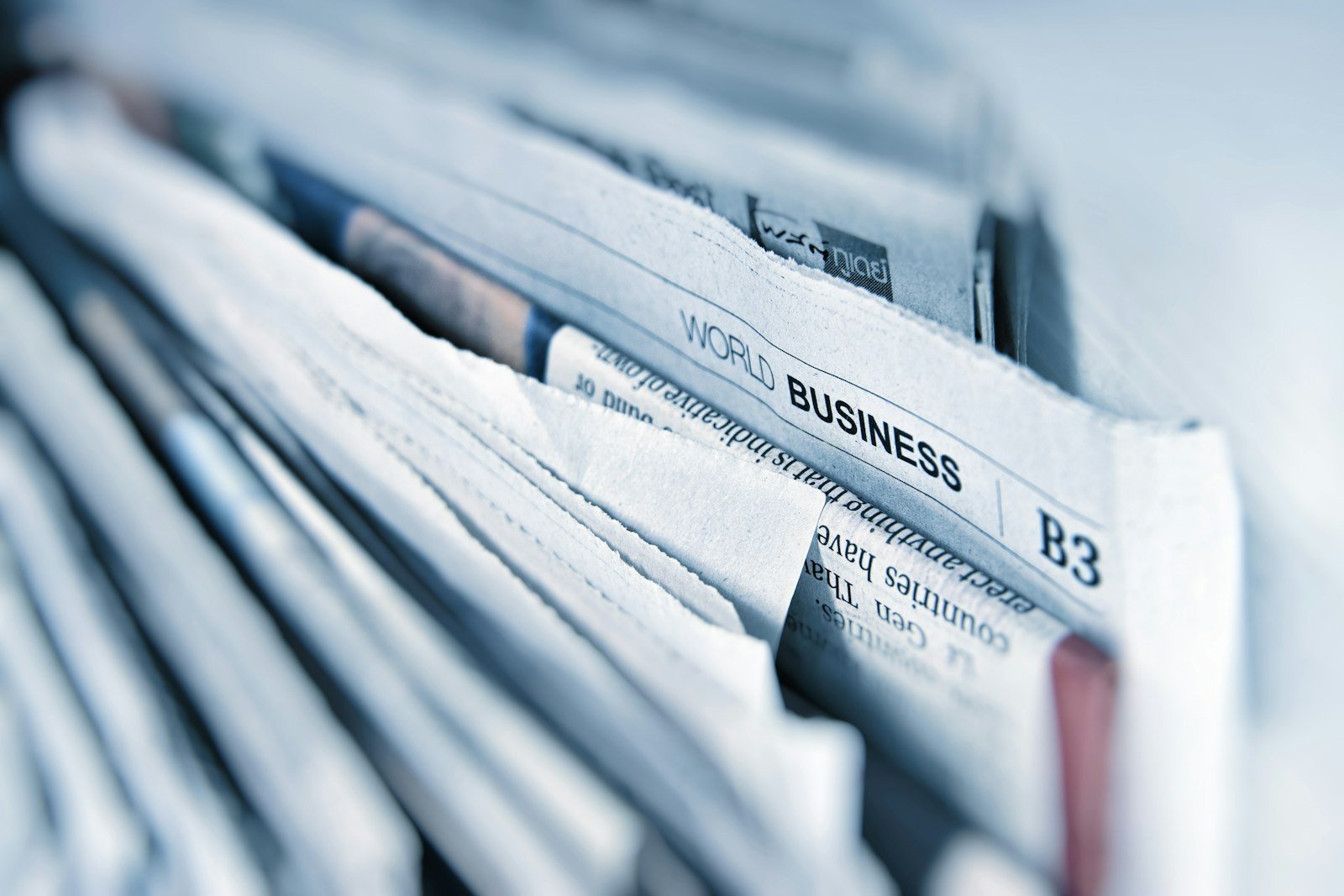 A close-up of folded newspapers stacked on a shelf